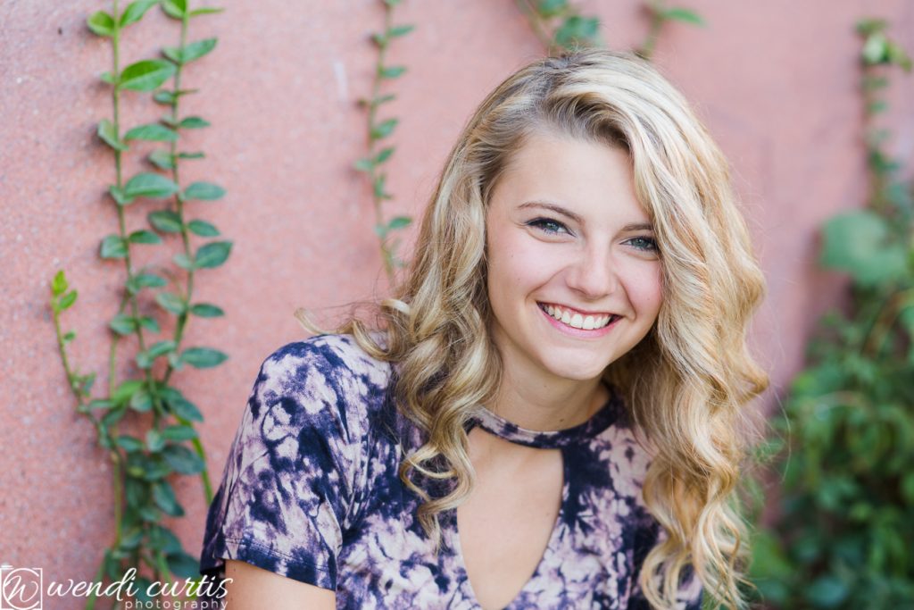 senior girl photo with pink wall
